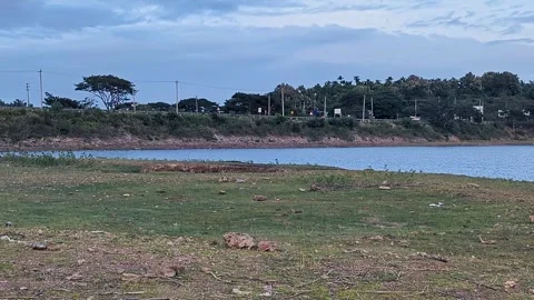 A pan shot of a large drought-stricken rural lake with stagnant water by an.. Stock-Footage 346816962