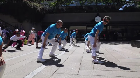 A pan shot of a large group of people exercising on Robson square of Vancouver Stock Footage 51332672