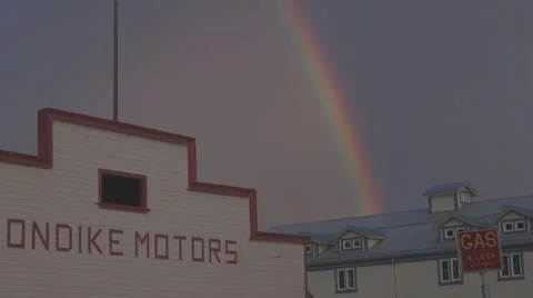 Pan shot to the left of a rainbow in a western town. Stock Footage 69064104