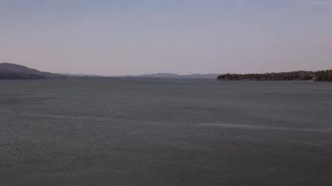 Pan shot left to right. Lake Champlain Bridge to Lake Champlains edge. Stock Footage 273607876