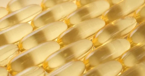 Pan shot, macro view: Vitamins supplements pills omega 3. Fish oil capsules. 4k Stockbeeldmateriaal 108103751