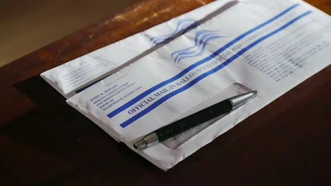 Pan shot of mail voting ballot envelope on table in 2020 Presidential Election Stock Footage