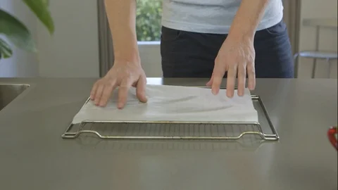 Pan Shot Of Man Laying Baking Paper On A Baking Tray Video stock 126985114