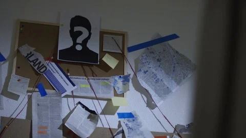 Pan Shot Of Man Looking At His Detective Work Vídeo Stock 127570397