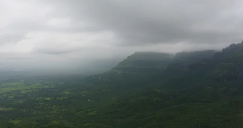 Pan shot of Mountain range in a lush green forest. Stock Footage 117096174