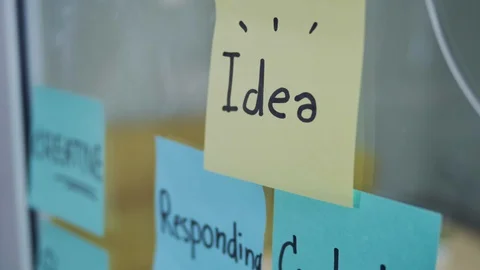 Pan Shot of Multiple Colourful sticky notes with text on glass whiteboard. Video stock 128252717