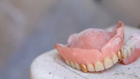 Pan shot of old denture on dirty white background Stock Footage 88919033