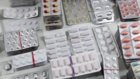 Pan shot over desk full of pills of all kinds in blisters Stock Footage 161029329