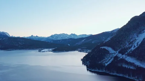 Pan shot over lake with mountain range in background in winter. Stock Footage