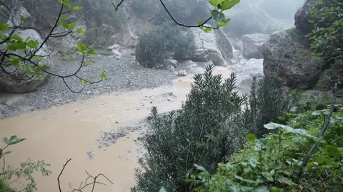 Pan up shot overlooking a small mountain river in Moroccco Stock Footage 100269347