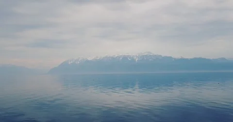 Pan shot of Serene view of calm blue lake waters under direct high noon sun with Video stock 331498950