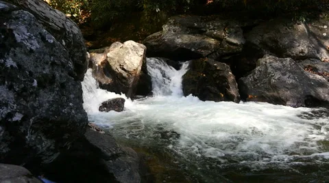 Pan shot in slow motion of rushing water in small river 스톡 동영상 56697815