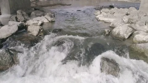 Pan shot of a small Waterfall Under industrial bridge of river, 4k Stock Footage 73026313