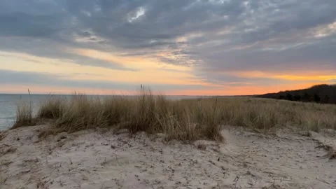 Pan shot of sunset over the Baltic Sea: beach, sand dunes, and beach grass .. Stock Footage 316699485