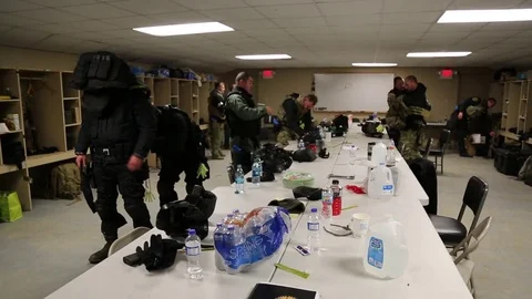 Pan Shot of SWAT Trainees Removing Tactical Gear in Tack Room Stock Footage 70562954
