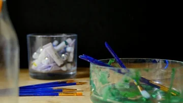 Pan shot through an art studio with paints and brushes and pencils  Stock Footage 85679423