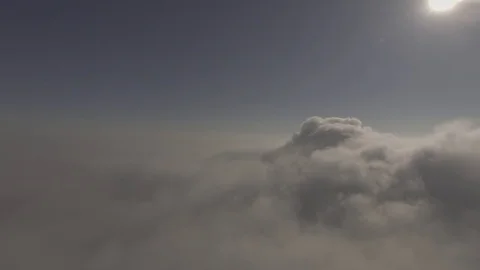 Pan shot of a top clouds accumulating with the sun in front, 4K Stock Footage 72908150