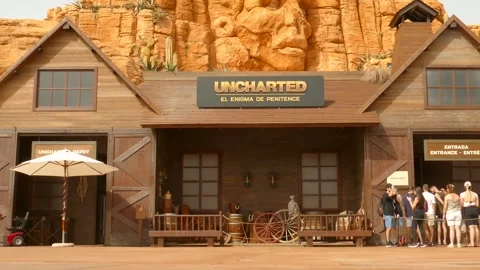 Pan shot of tourists standing in que in front of Uncharted ride in the Far Stock Footage 253626484