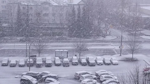 Pan shot of traffic flow and parking lot on cold blizzard snow winter day Video stock 70346568