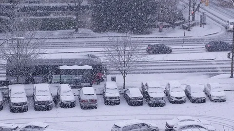 Pan shot of traffic flow and parking lot on cold blizzard snow winter day Video stock 70378536
