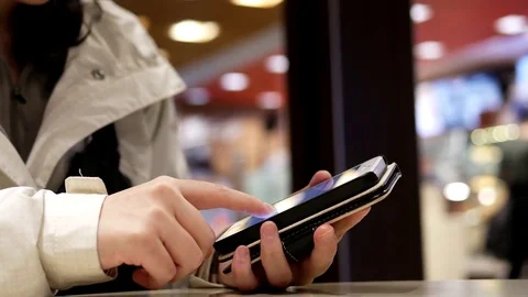 Pan shot of woman using her mobile phone inside Mcdonalds restaurant Stock Footage 71754875