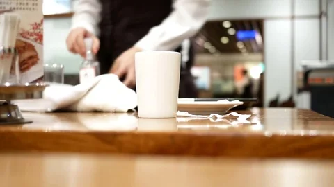 Pan shot of worker cleaning table after customer eating food inside restaurant Stock Footage 82551253