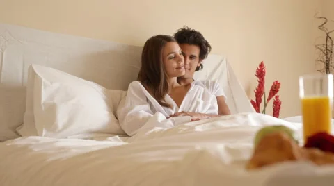 Pan shot of young couple in bed with breakfast Stock Footage 43614920