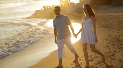 Pan shot of young couple walking on beach Stock Footage 43620179