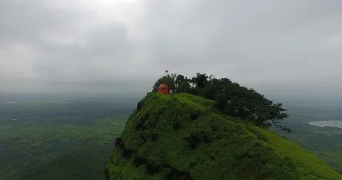 Pan shots of a temple structure on top of a mountain in a lush green forest Stock Footage 117093370
