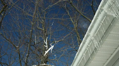 Pan from sky to icicles on house gutter 4K Stock Footage 45920582