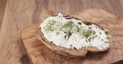 Pan slow motion of arugula fall on rustic bread with ricotta cheese Stock Footage 75346392