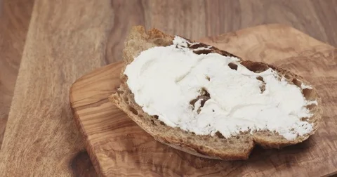 Pan slow motion of arugula fall on rustic bread with ricotta cheese Stock Footage 77872262