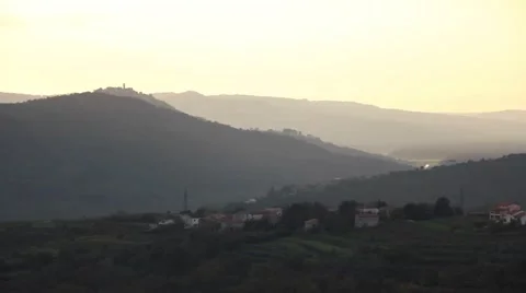 Pan on a small town over the hills with the sunset Stock Footage 47993983