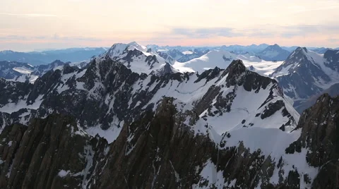 Pan of snowy mountain range at dawn Video stock 55539340
