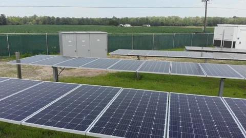 Pan of a solar panel field and large energy storage battery Stock Footage 129765098