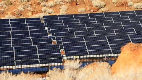 Pan of Solar Panels in Desert with Red Rocks - Shallow Depth of Field Stock Footage 103122644