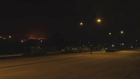 Pan of street with flames in background Stock Footage 79632516