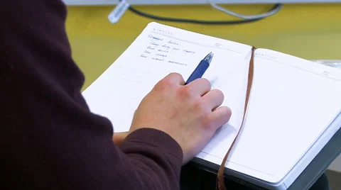 Pan to Student Resting Hand on Notebook Stock Footage 61636261