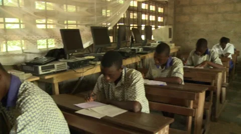 PAN: STUDENTS AND TEACHER IN CLASSROOM WITH WOODEN DESKS Stock Footage 60627360