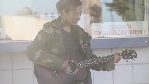 Pan from sun to kid on guitar Stock Footage 122724574