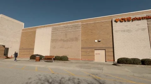 Pan of a Target retail store and person walking with parked cars and blue sky Stock Footage 148750457