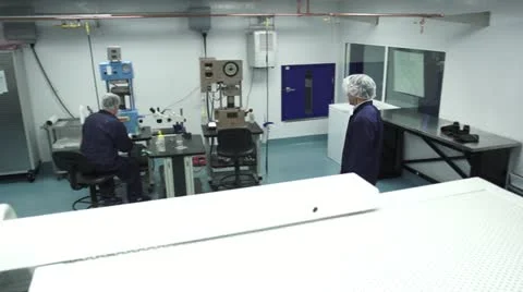 Pan from technician walking to technician at Machine in Cleanroom Stock Footage 10895664