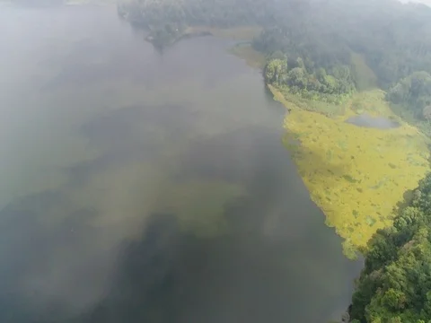 Pan up through clouds, over lake in Bali Indonesia. Stock Footage 80139206