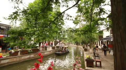 Pan through flowers and boating by the river in Zhujiajiao, China Video stock 12410698