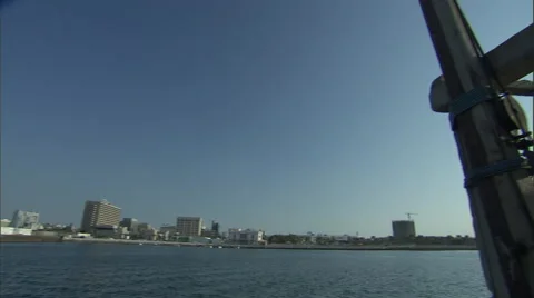 Pan towards a tall building situated in Dubai, seen from a boat. Stock Footage 46868832