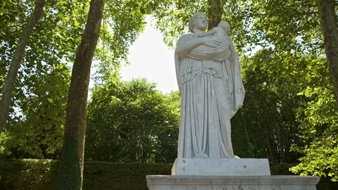 Pan tracking shot of statue in Versailles gardens alley in spring 스톡 동영상 117372840