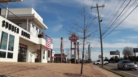 Pan of Traffic and a building with a large American flag Arbys in the backgou Stock Footage 148962547