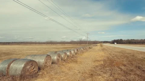 Pan of traffic on highway 1 and hay bales on farm land Stock Footage 147233936