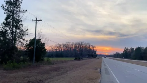 Pan of traffic on highway 1 in Burke County Georgia in the evening at golden  Stock Footage 147096972