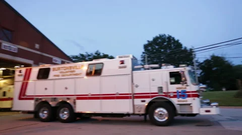 Pan to two firemen talking outside of a fire department Stock Footage 66548682